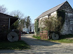 millstones leaning against old farm buildings